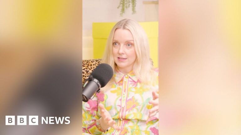 Lauren Laverne: 'Cancer never leaves you' A woman with shoulder-length blonde hair wearing a floral shirt sits in front of a microphone and talks to someone off-camer