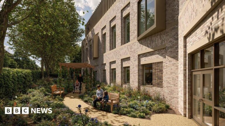 Cheltenham’s new £12m cancer centre reaches ‘significant milestone’ A computer generated image showing plans for a new cancer care centre. It shows the outside of a building with brown bricks, a number of windows and a door. There are two benches outside in a garden with two seat sat on one on the benches and a person being pushed in a wheelchair along a path