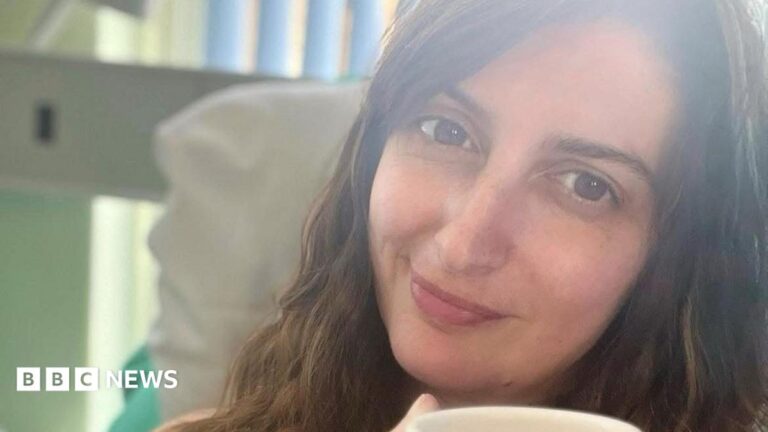 Cornwall bowel cancer campaign aims to boost early diagnosis A woman with long hair holds a mug while looking at the camera in bed.