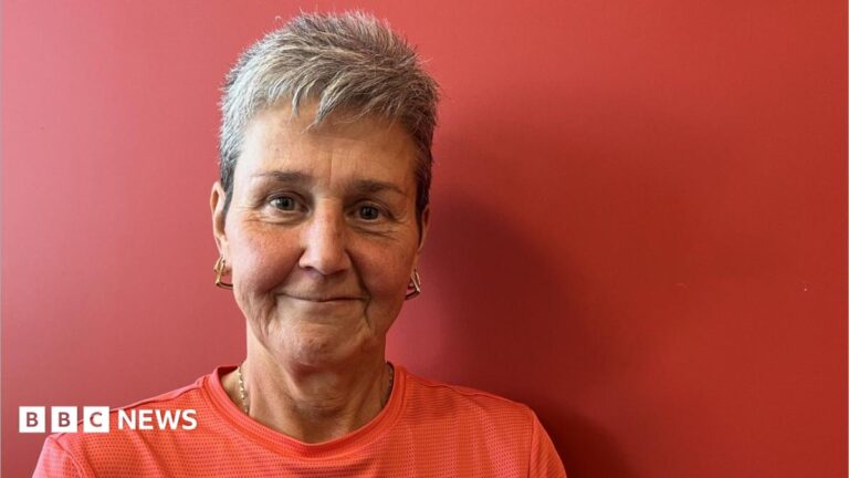 Middlesbrough FC Foundation cancer fitness group ‘saved me’ A woman with short blonde hair in black and pink gym attire, her arms are up and she is leading a fitness class. There are weights and a stepper in front of her. There are other people taking part in the class around the room.