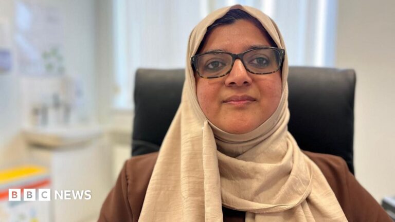 GP appointment time ‘making it harder to do cancer checks’ Dr Amara Naseem is sitting in a GP's surgery, she is wearing a cream-coloured headscarf and a light brown top. She has on rectangular tortoiseshell glasses and a medical bin can be seen over her right shoulder